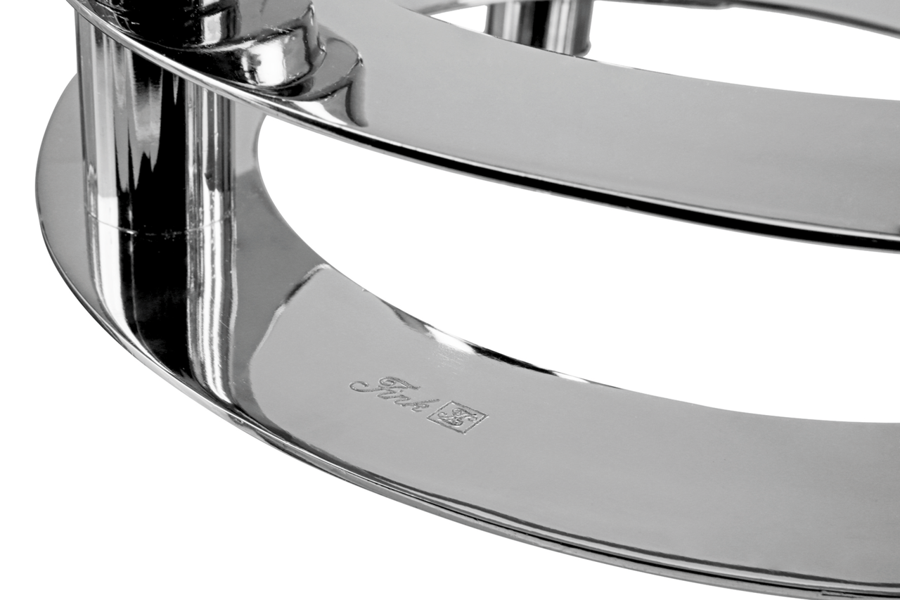 Nahaufnahme eines glänzenden, verchromten Teils eines 4-flammigen Leuchters mit eingraviertem Logo, seitliche Perspektive.
