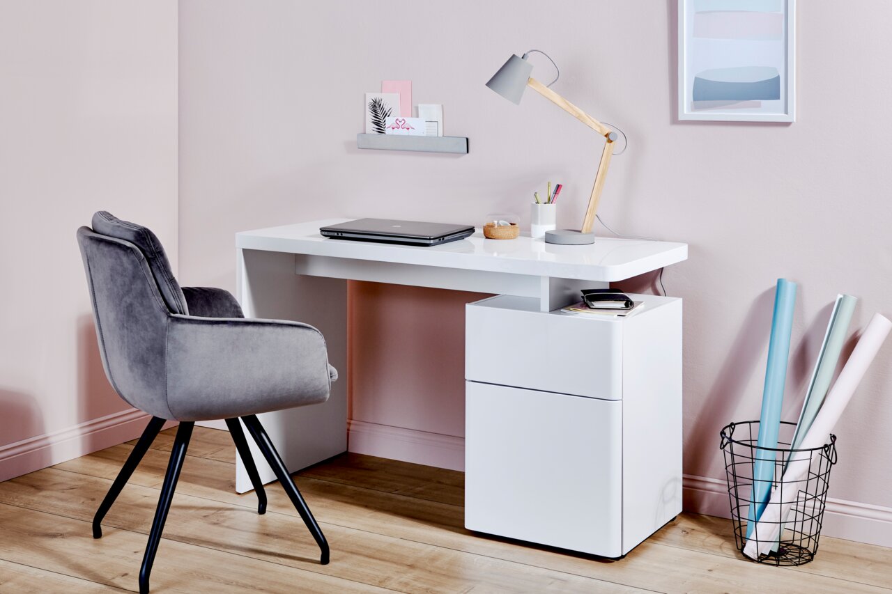 Moderner weißer Schreibtisch mit Schubladen, Laptop und Lampe, seitliche Perspektive