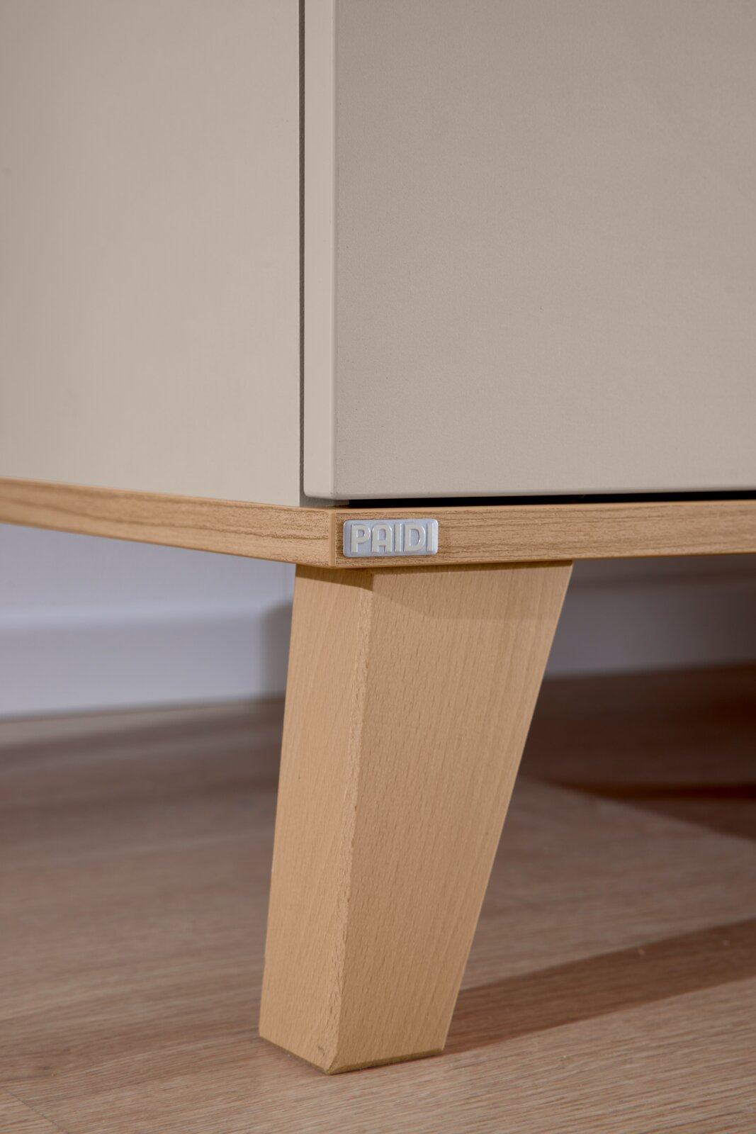 Nahaufnahme eines Standregals mit Holzfuß und Metallplakette, seitliche Perspektive