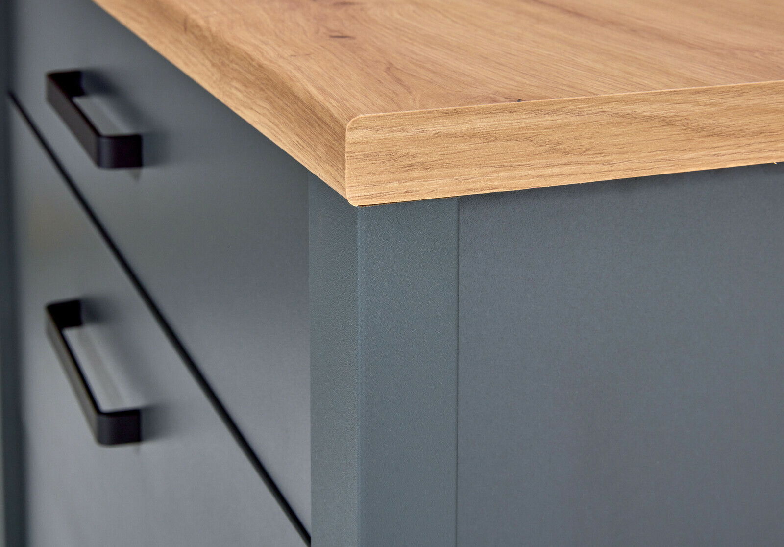 Nahaufnahme eines Schubkastenunterschranks mit grauer Front und Holzarbeitsplatte, seitliche Perspektive.