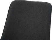 Nahaufnahme der dunkelgrauen, stoffbezogenen Rückenlehne eines Stuhls mit abgerundeten Ecken, schräg von vorne oben fotografiert