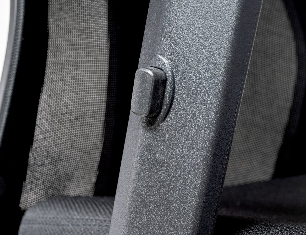 Nahaufnahme eines Drehstuhls mit Netzrückenlehne und einem Einstellknopf an der Seite.