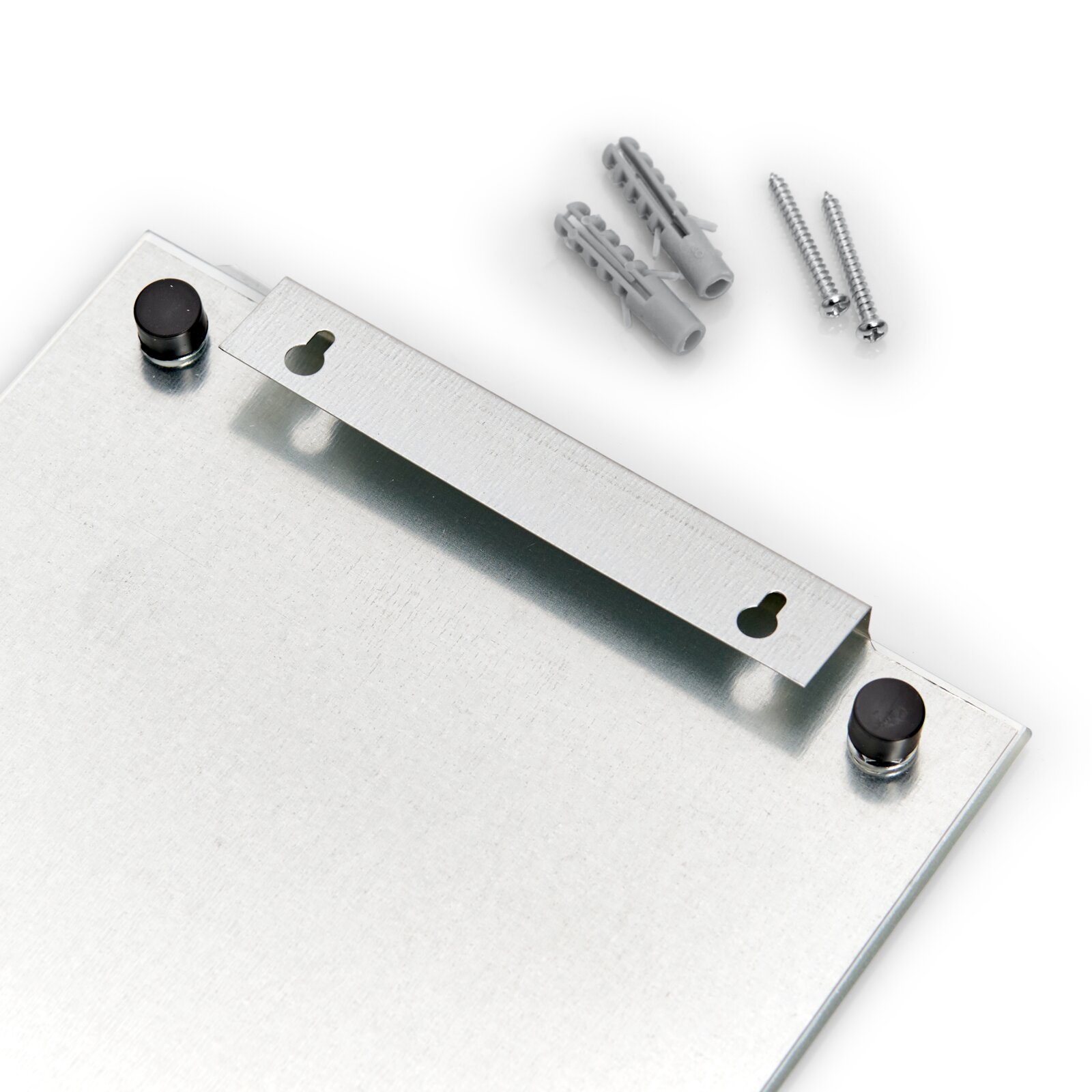 Nahaufnahme eines Memoboards mit Haken, Schrauben und Dübeln, von oben betrachtet.