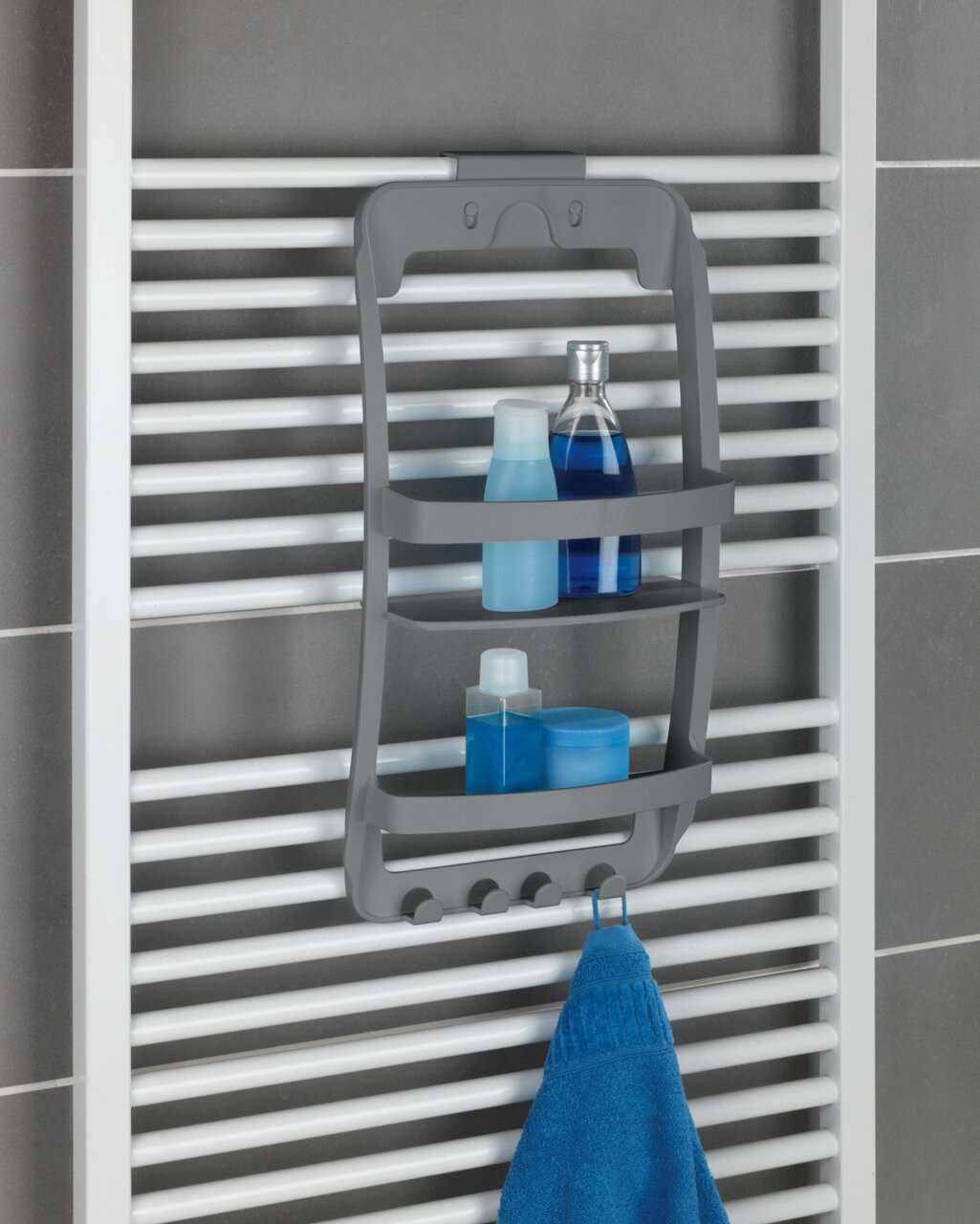 Grijze badkamerrek Universal, bevestigd aan een wit handdoekradiator, met twee legplanken voor douchebenodigdheden en haken voor handdoeken, zijaanzicht.