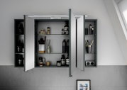 Moderner Spiegelschrank mit geöffneten Türen, gefüllt mit Pflegeprodukten und Accessoires, aus der Frontalperspektive betrachtet.