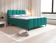 Modernes Boxbett in Türkis mit gepolstertem Kopf- und Fußteil, seitliche Perspektive im stilvollen Schlafzimmer.