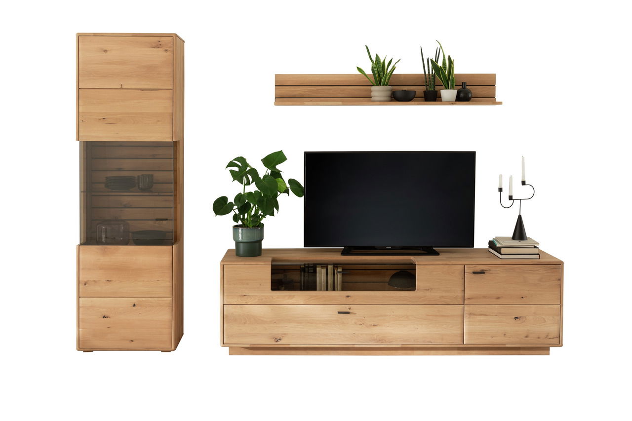 Wandkombination aus Holz mit einem hohen Schrank, einem TV-Schrank und einem Wandregal, dekoriert mit Pflanzen und Kerzenhaltern, frontal betrachtet.