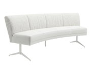 Moderne gebogen eetkamerbank zonder armleuningen, met witte bekleding, zachte bouclé rugleuning en slanke metalen poten, schuin van voren weergegeven