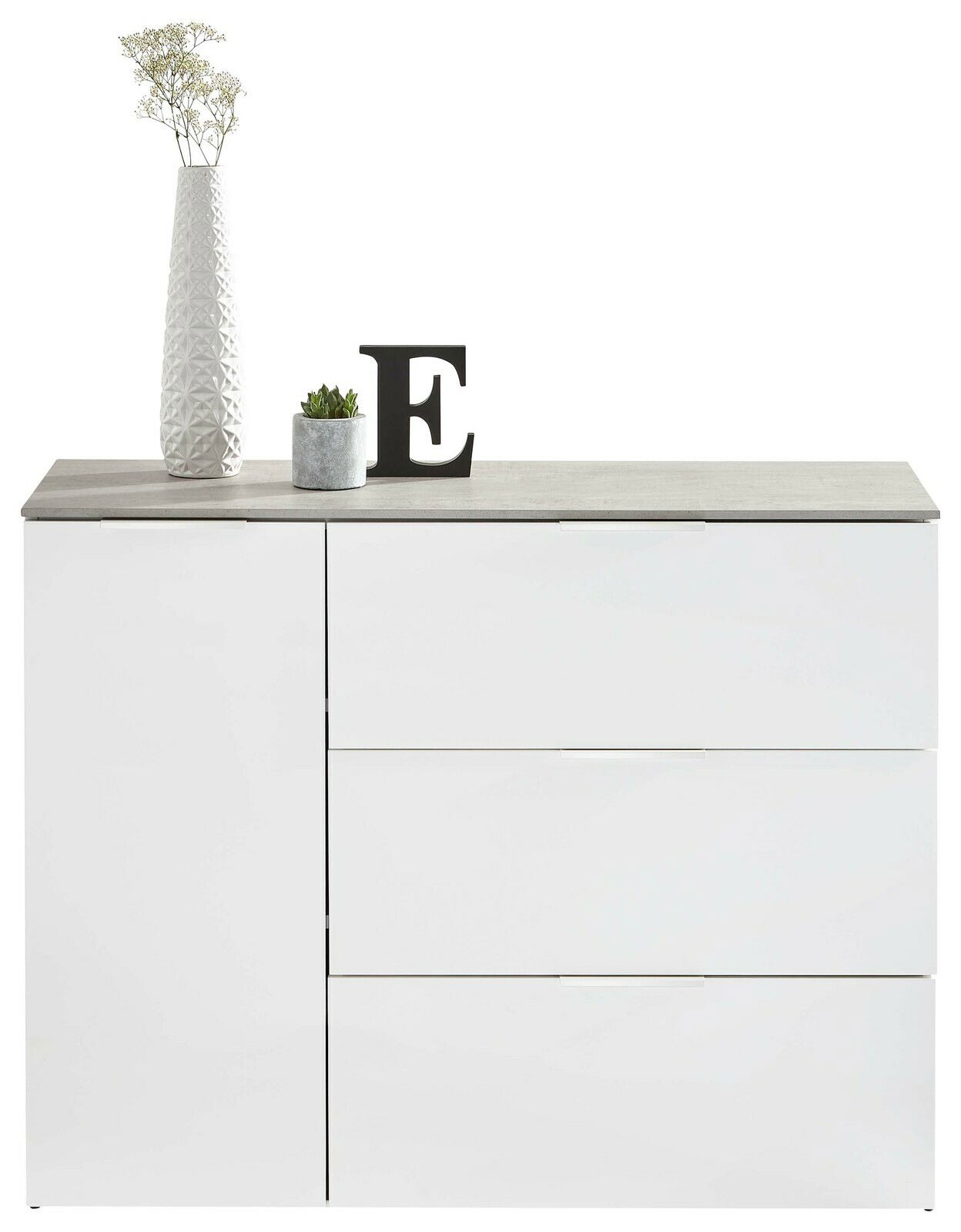 Modernes weißes Sideboard mit drei Schubladen und einer Tür, dekoriert mit einer hohen Vase, einer kleinen Pflanze und einem Buchstaben E, frontal betrachtet.