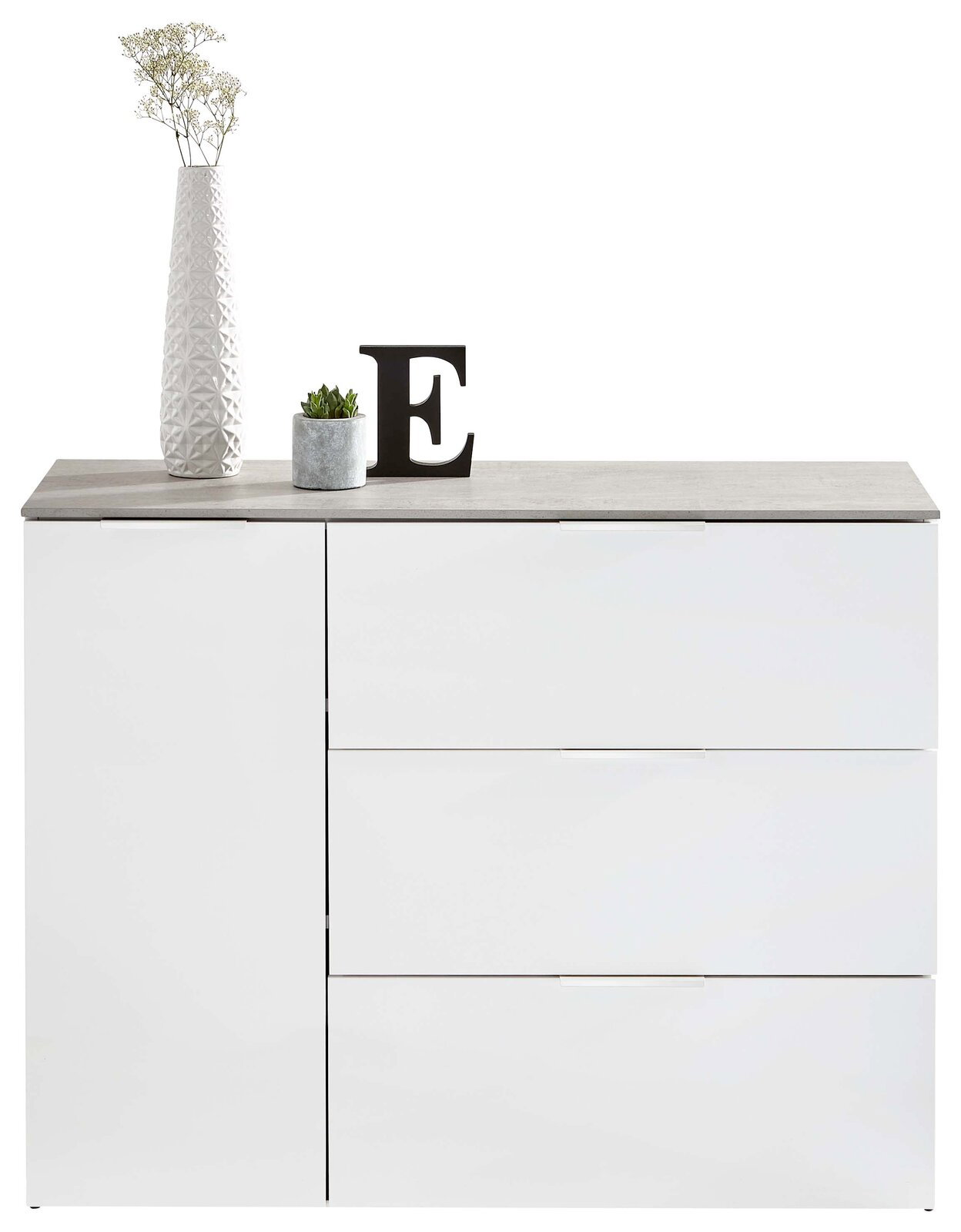 Modernes weißes Sideboard mit drei Schubladen und einer Tür, dekoriert mit einer hohen Vase, einer kleinen Pflanze und einem Buchstaben E, frontal betrachtet.