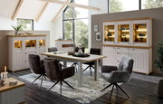 Esszimmer mit modernem Design, bestehend aus einem großen Holztisch und sechs gepolsterten Stühlen mit schwarzem Metallgestell, in einem hellen Raum mit großen Fenstern und stilvollen Vitrinen. Perspektive: seitlich.