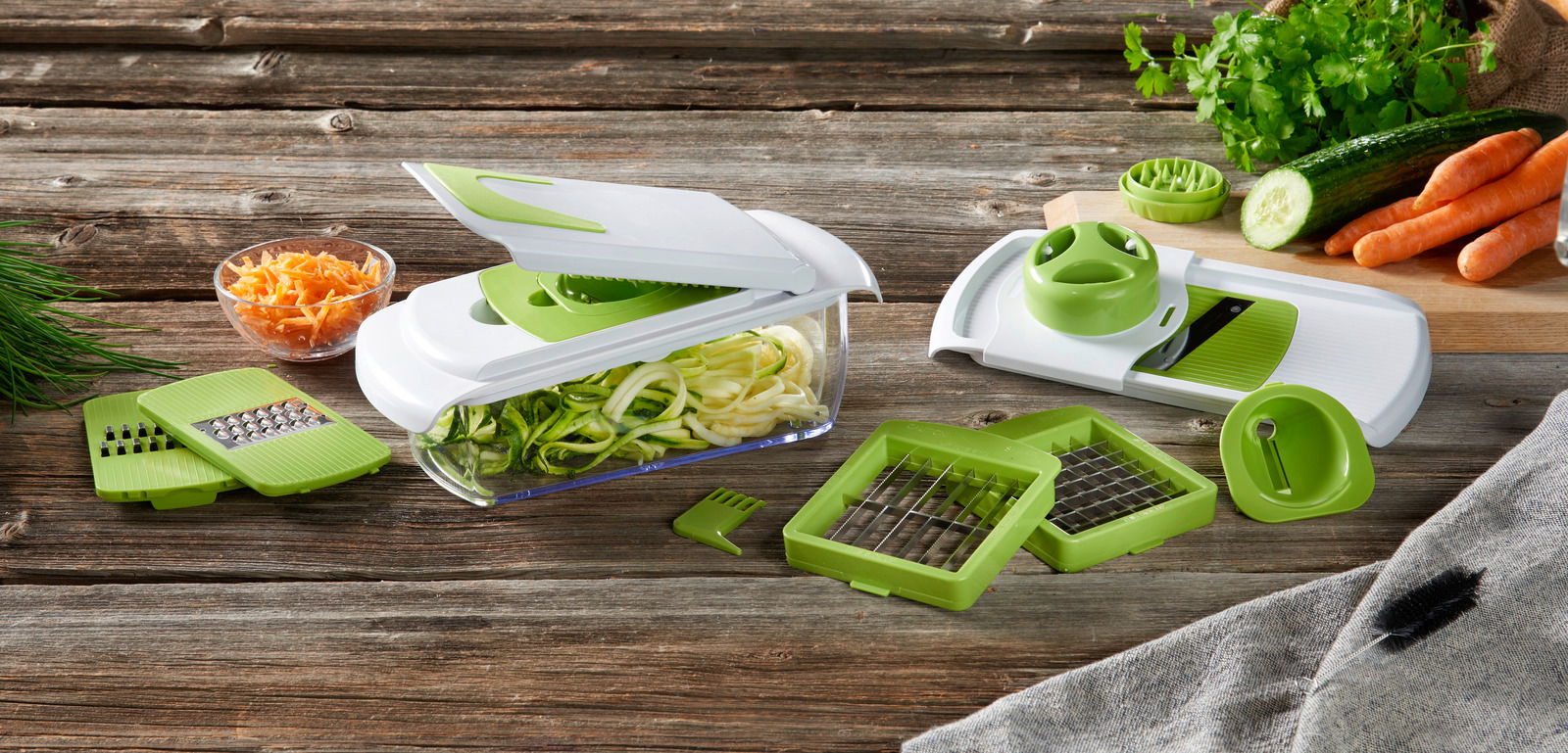 Homeware Allesschneider 14tlg. Vielseitiger Allesschneider mit 14 Teilen, inklusive verschiedener Klingen und Zubehör, aus der Seitenperspektive gezeigt. Ideal zum Schneiden von Gemüse wie Zucchini und Karotten.