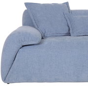Nahaufnahme einer blauen Rundecke des Ecksofas PONTO mit weichen Kissen, seitliche Perspektive