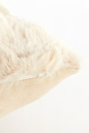 Nahaufnahme eines Kissens mit weicher, flauschiger Oberfläche und sichtbarem Reißverschluss, seitliche Perspektive