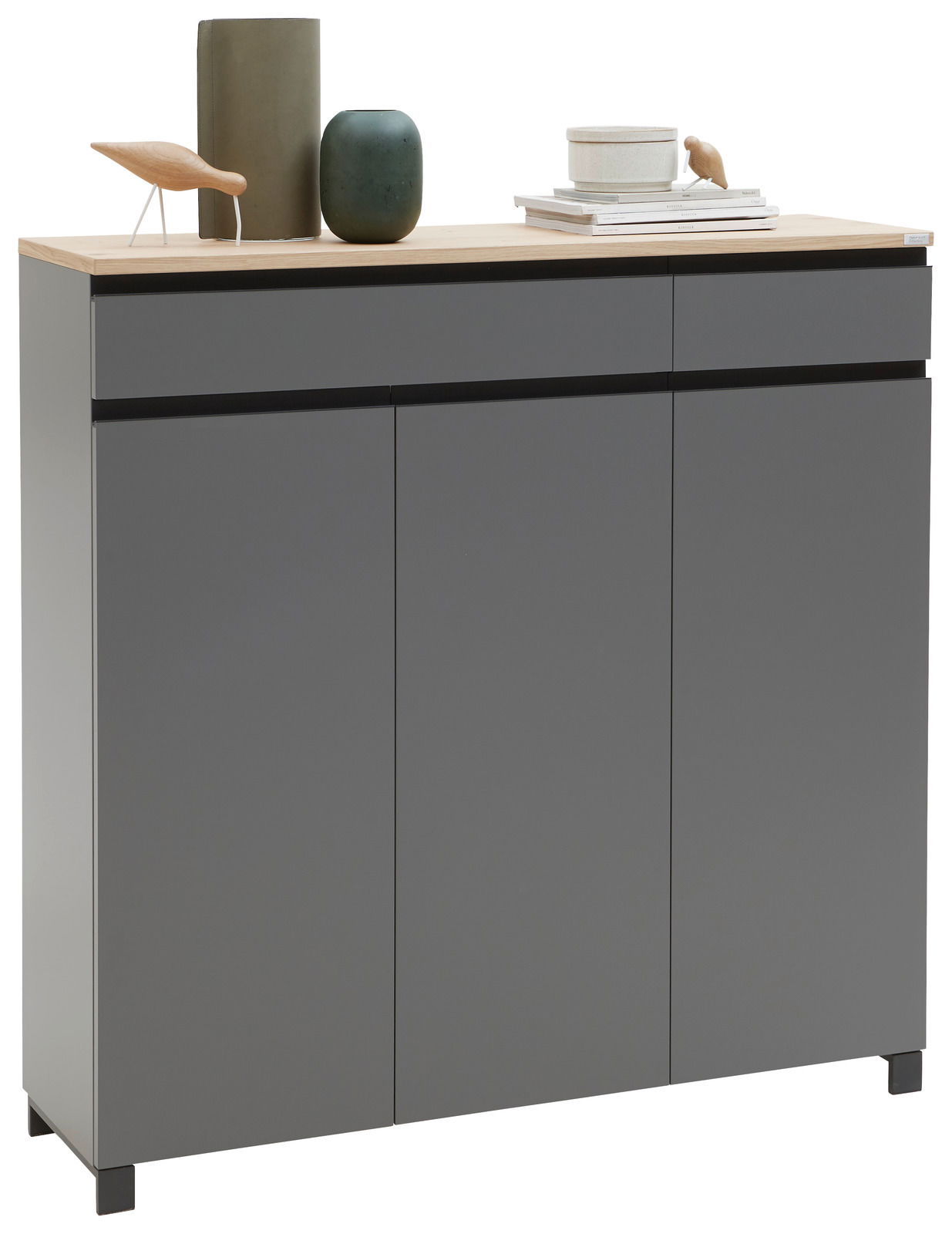 Moderner grauer Schuhschrank mit drei Türen und zwei Schubladen, dekoriert mit Vasen und Büchern, aus frontaler Perspektive.