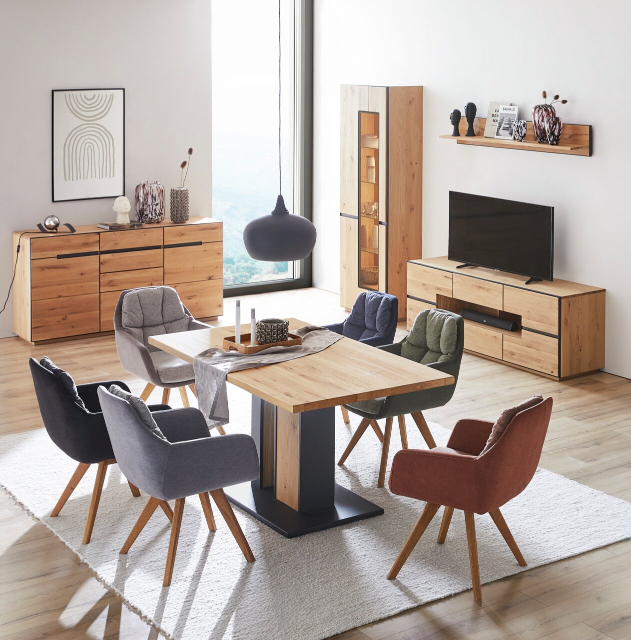 Modernes Wohnzimmer mit einem Sideboard aus Holz, umgeben von stilvollen Möbeln und Dekorationen, aus einer leicht erhöhten Perspektive betrachtet.