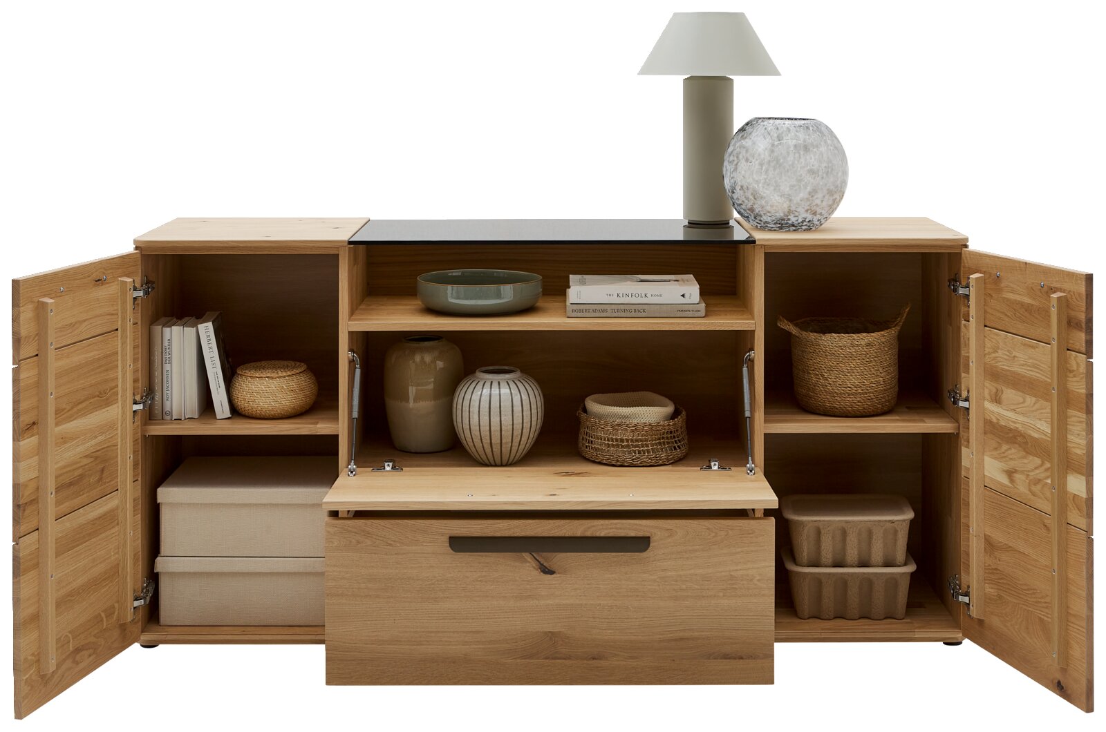 Massives Holz-Sideboard/Kommode mit drei geöffneten Klapptüren, mittigem Auszug und Regalfächern, dekoriert mit Vasen, Büchern und Körben, frontal aus leicht erhöhter Perspektive.