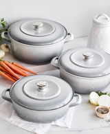 Drei Fleischtöpfe in galaxy grey aus der Vogelperspektive, umgeben von frischen Zutaten wie Karotten und Zwiebeln.