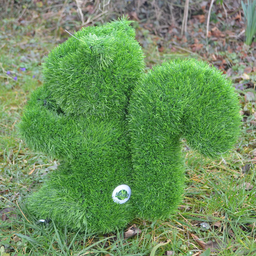 Grüne, grasbedeckte Eichhörnchen-Gartenfigur von der Seite, auf einer Wiese platziert.