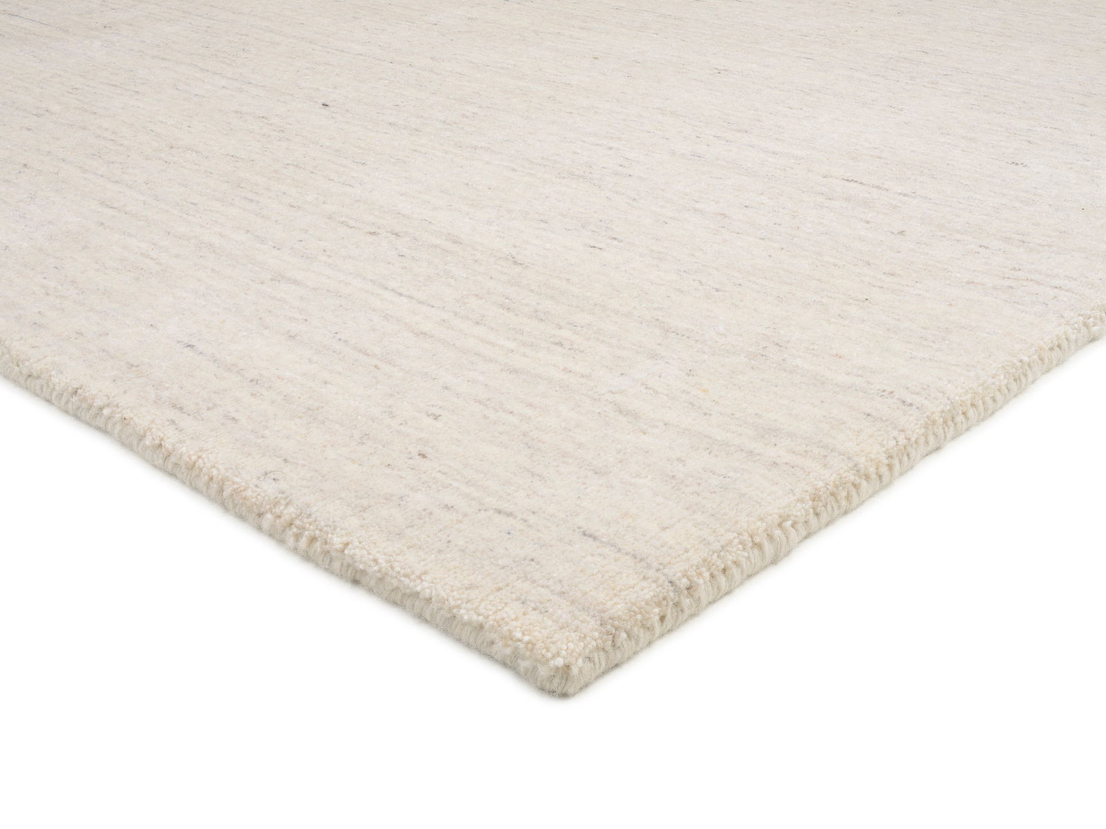 Nahaufnahme eines hellen Wollteppichs aus seitlicher Perspektive.