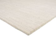 Nahaufnahme eines hellen Wollteppichs aus seitlicher Perspektive.