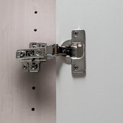 Nahaufnahme eines Scharniers an einem Drehtürenschrank, seitliche Perspektive