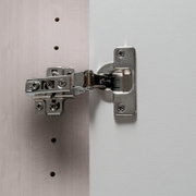 Nahaufnahme eines Scharniers an einem Drehtürenschrank, seitliche Perspektive