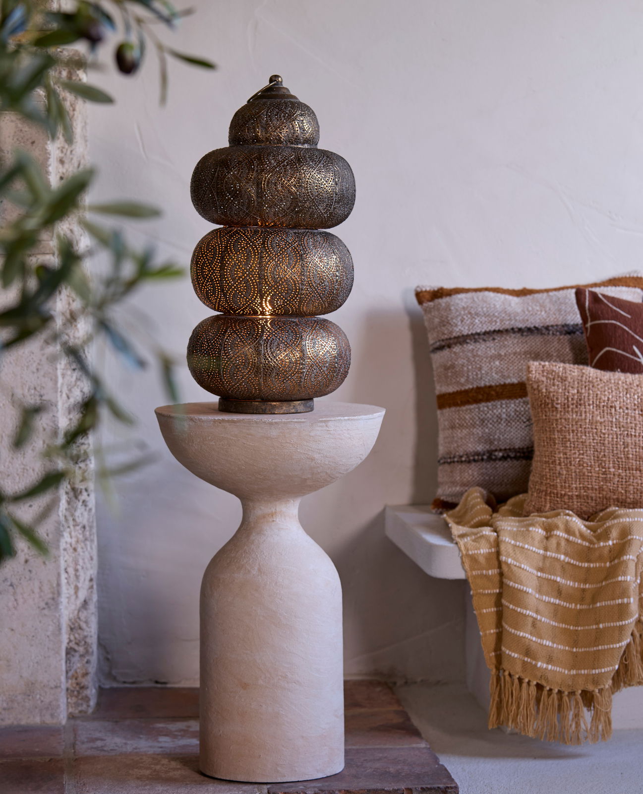 Orientalische Tischleuchte mit filigranem Muster, auf einem sandfarbenen Sockel, seitliche Perspektive