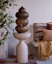 Orientalische Tischleuchte mit filigranem Muster, auf einem sandfarbenen Sockel, seitliche Perspektive