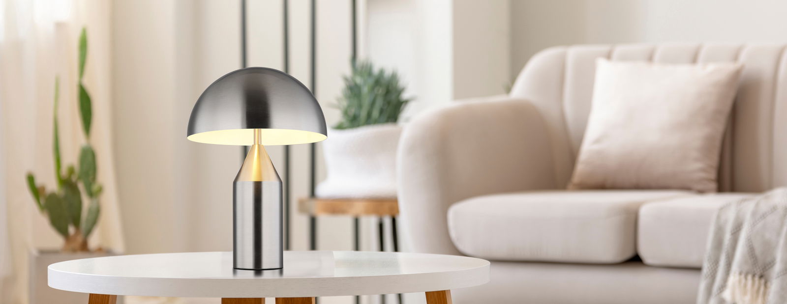 Moderne Tischleuchte ATOMA aus Metall in einem stilvollen Wohnzimmer, seitliche Perspektive.