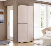 Hochglanz-Schrank in hellem Beige mit zwei Türen und mittlerer Griffleiste, freistehend in modernem Wohnraum neben Fenster mit Vorhängen, Perspektive: frontale Ansicht mit leichtem Blick von links