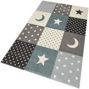 Teppich mit blau-grauen Quadraten, verziert mit Sternen, Monden und Punkten, aus schräger Perspektive fotografiert.