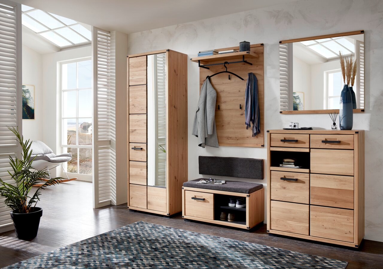 Linea Natura Spiegel GENUA II Moderne Garderobeneinrichtung aus Holz mit Garderobenschrank, Schuhschrank, Garderobenpaneel, Spiegel und Garderobenbank in einem hellen Raum mit großen Fenstern, seitliche Perspektive.