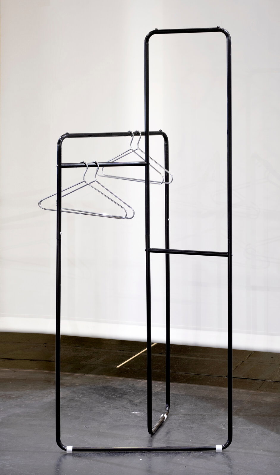 Schwarze Standgarderobe aus Metall mit mehreren Kleiderbügeln, seitliche Perspektive.