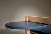 Nahaufnahme eines blauen, runden Tisches mit Holzrahmen, seitliche Perspektive