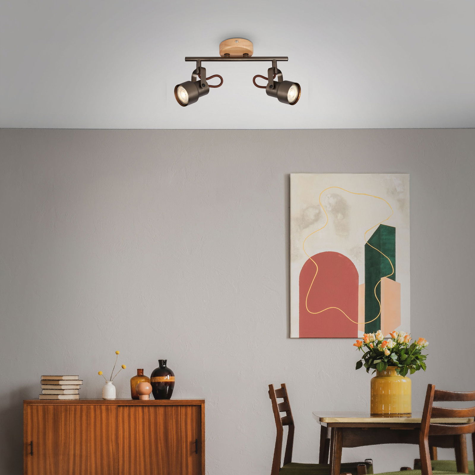 Zweiflammige Spotleuchte TAHUN von Briloner, an der Decke montiert, in einem modernen Wohnzimmer mit abstraktem Kunstwerk und Holzmöbeln, seitliche Perspektive.