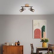 Zweiflammige Spotleuchte TAHUN von Briloner, an der Decke montiert, in einem modernen Wohnzimmer mit abstraktem Kunstwerk und Holzmöbeln, seitliche Perspektive.