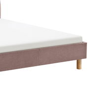 Nahaufnahme eines Polsterbetts mit hellbraunem Stoffbezug und Holzfüßen, seitliche Perspektive.