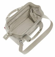 Innenansicht einer beigen Tasche mit Reißverschluss und Schultergurt, von oben fotografiert.