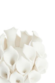 Nahaufnahme eines weißen Teelichthalters mit blütenähnlichen Strukturen, von oben betrachtet.