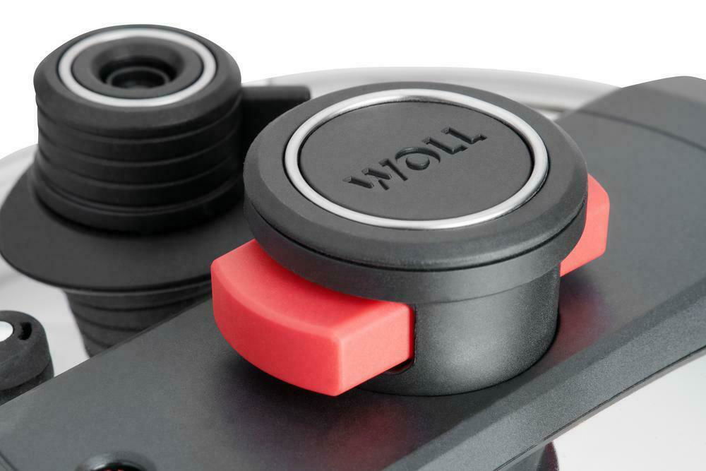 Nahaufnahme eines Schnellkochtopf-Ventils mit rotem Sicherheitsgriff und schwarzem Deckel mit der Aufschrift 'WOLL'.