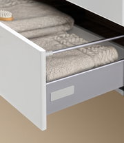 Nahaufnahme einer geöffneten Schublade eines Badblocks mit weißen Handtüchern, seitliche Perspektive