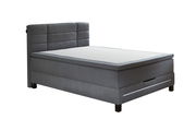 Graues Boxspringbett mit gepolstertem Kopfteil, seitlicher Perspektive