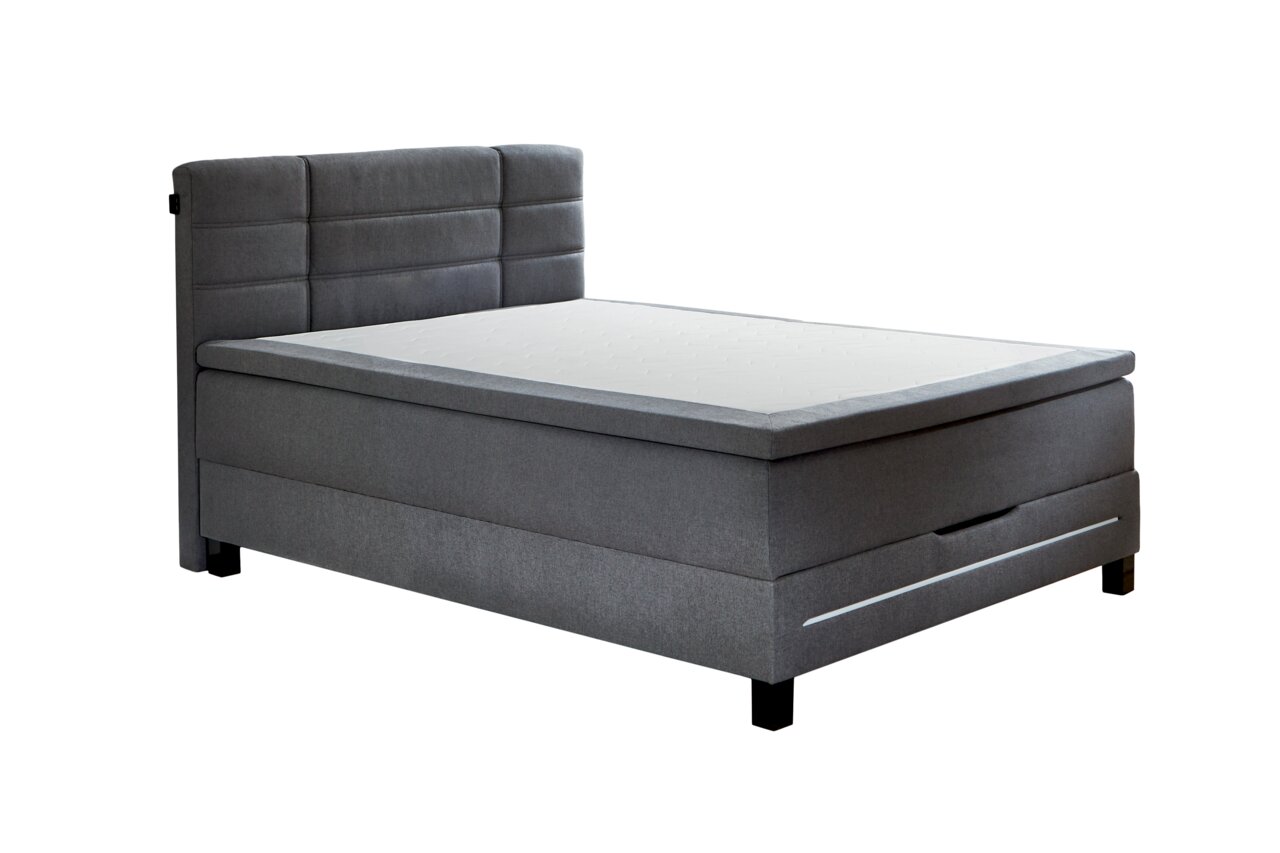 Graues Boxspringbett mit gepolstertem Kopfteil, seitlicher Perspektive
