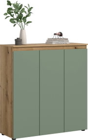 Moderne Kommode/Sideboard mit drei grün-matten Türen und Korpus in Holzoptik, auf der Deckplatte Vase mit grünen Zweigen und Bücherstapel; Ansicht schräg von vorne links