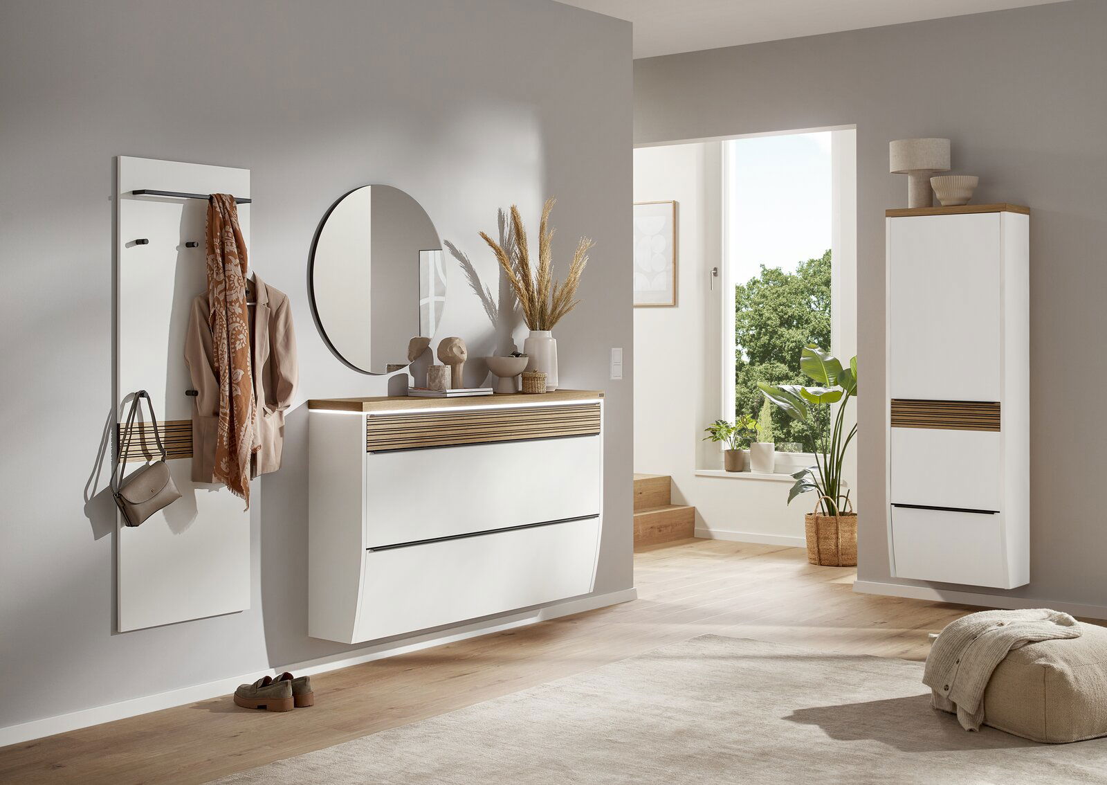 Dieter Knoll XXL-Hängeschuhschrank ARCO NOVA Moderner Eingangsbereich mit weißem Hängeschuhschrank, rundem Spiegel und Garderobenpaneel, seitliche Perspektive.