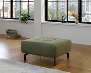 Groene XL-poef in een moderne woonkamer met houten vloer, zijaanzicht.