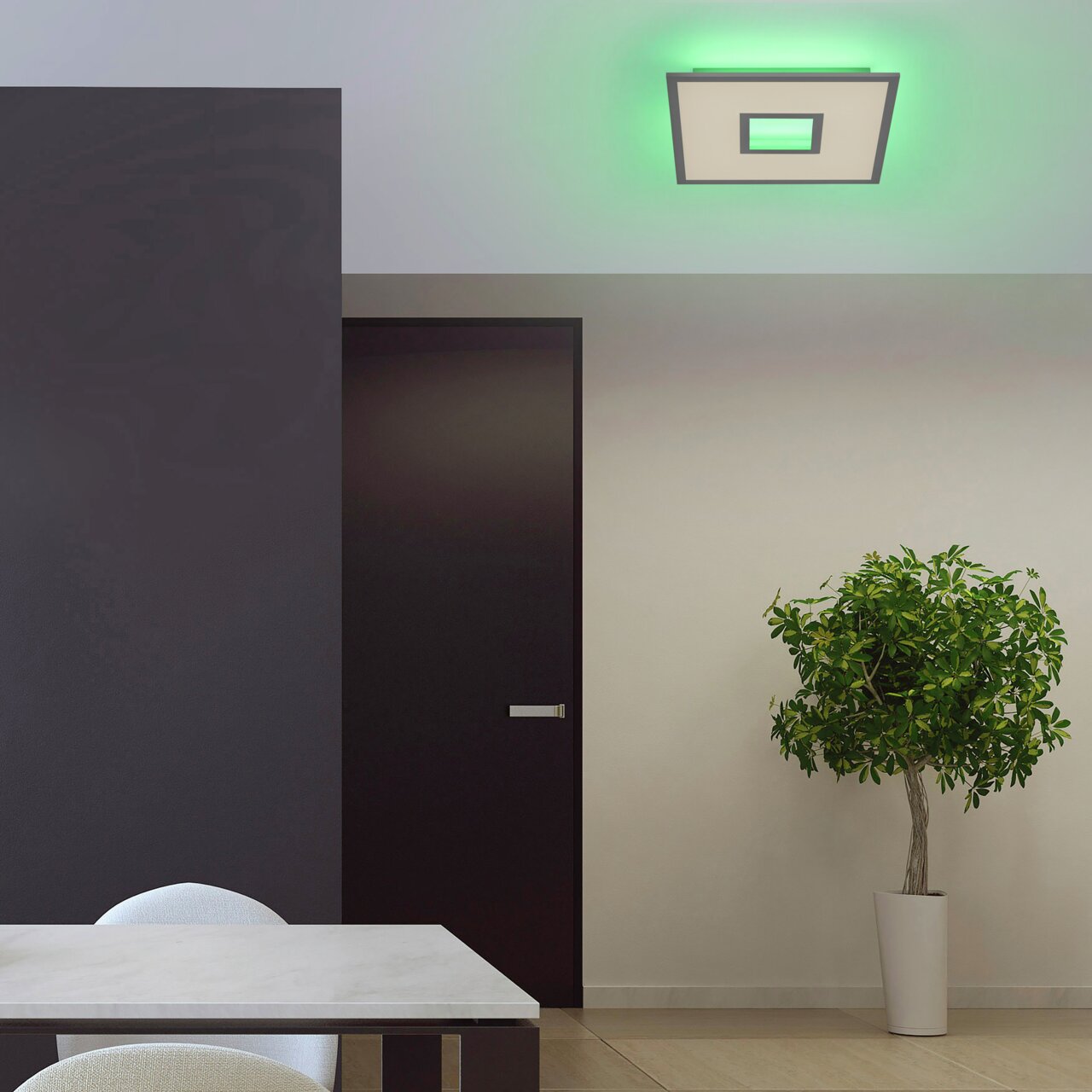 Moderne weiße Deckenleuchte RECESS mit grünem Lichtschein, von unten betrachtet in einem stilvollen Raum mit Tisch, Tür und Pflanze.