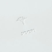 Nahaufnahme eines großen, weißen runden Tabletts mit geprägtem Logo und Blumenmotiv.