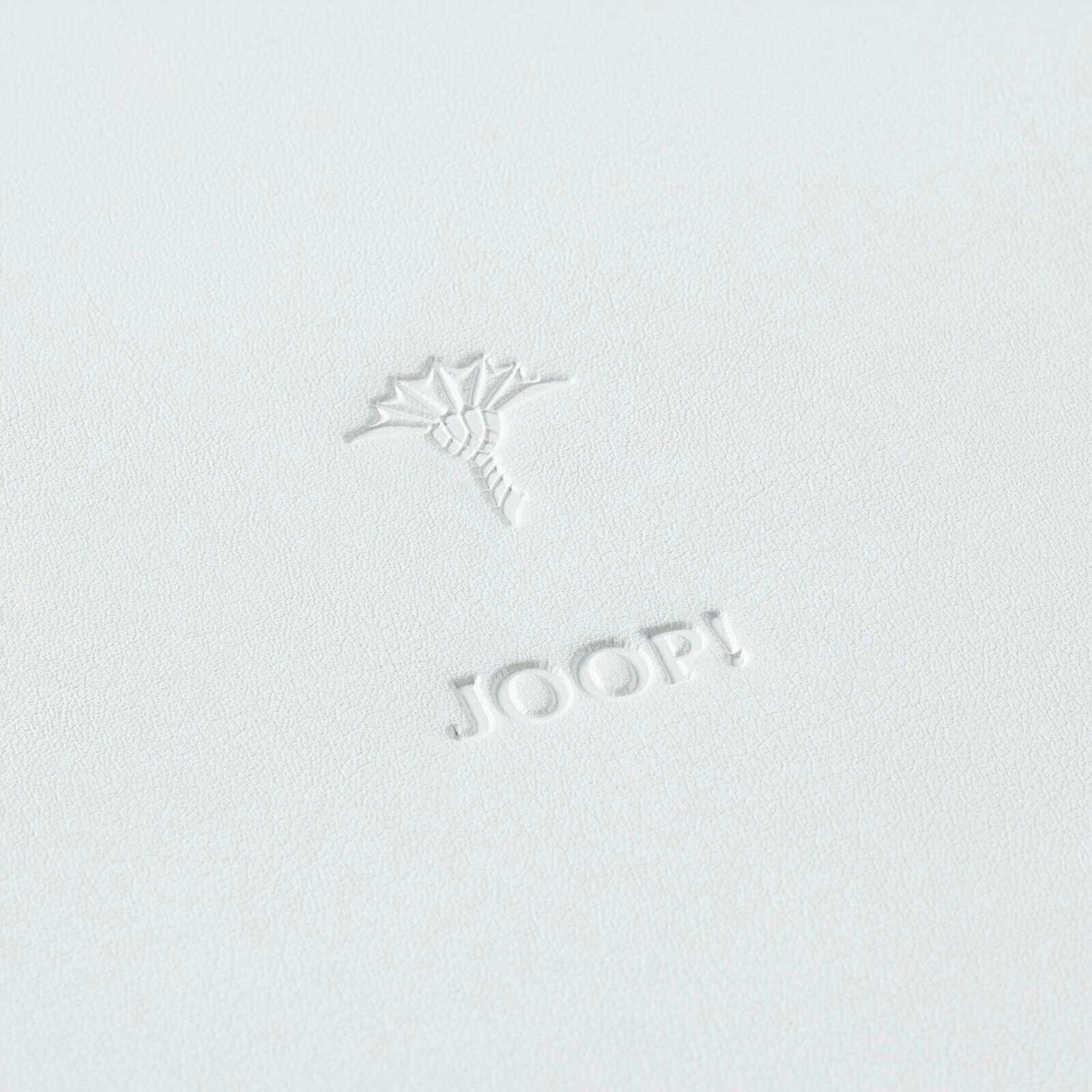 Nahaufnahme eines großen, weißen runden Tabletts mit geprägtem Logo und Blumenmotiv.